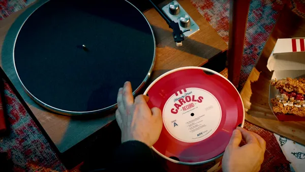 A screenshot of a YouTube video showing KFC's paper bucket lid that doubles as a record.