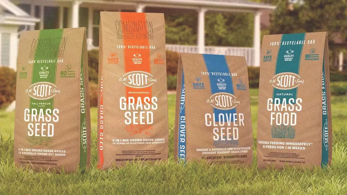 Four bags of ScottsMiracle-Gro lawn care products in paper bags.