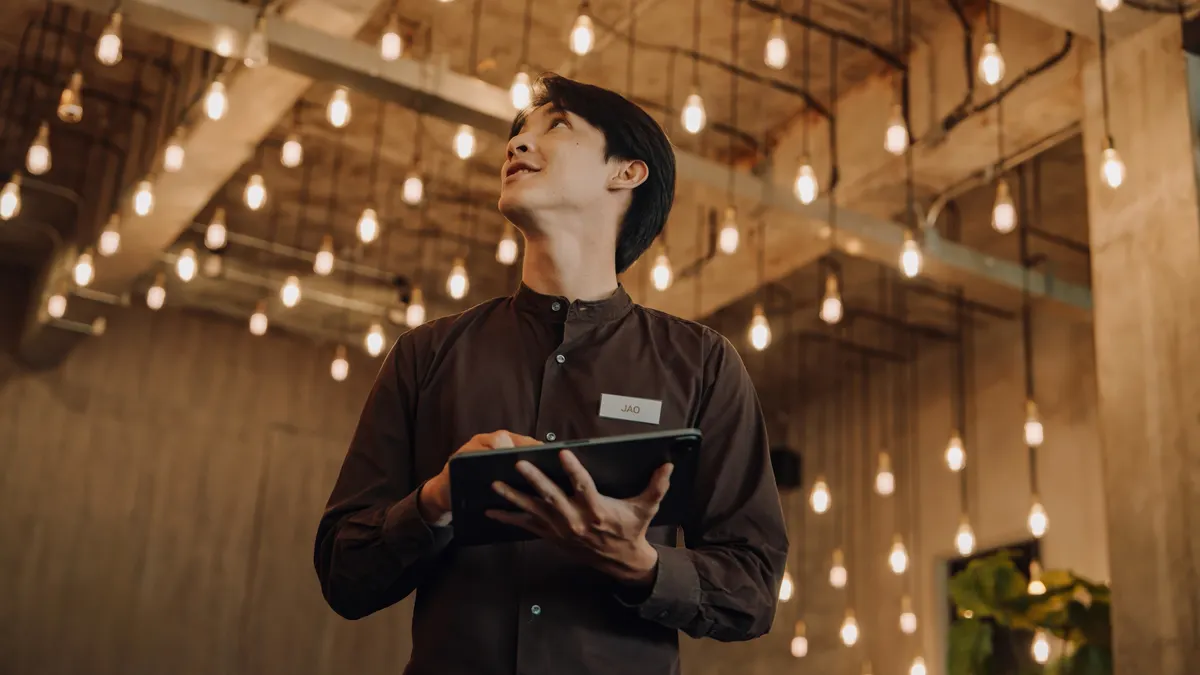 A hotel staffer holds a tablet.