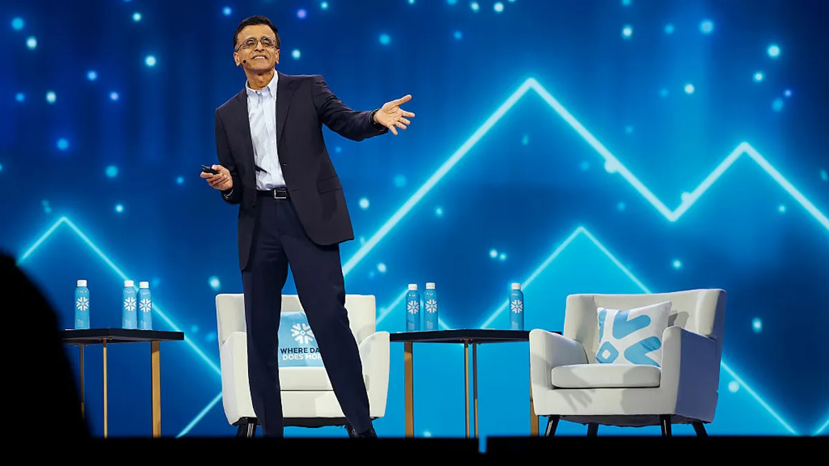 an executive speaks on stage in business attire