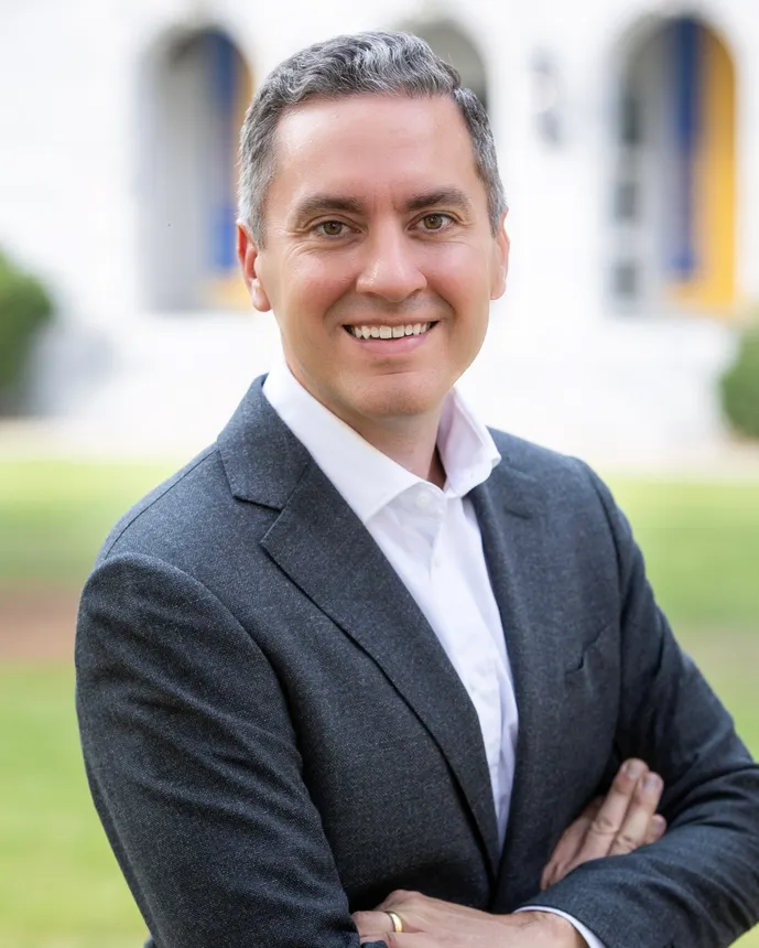 A person dressed in business attire smiles for a portrait.