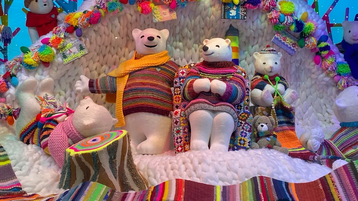 Macy's holiday window with a family of polar bears wearing winter apparel.