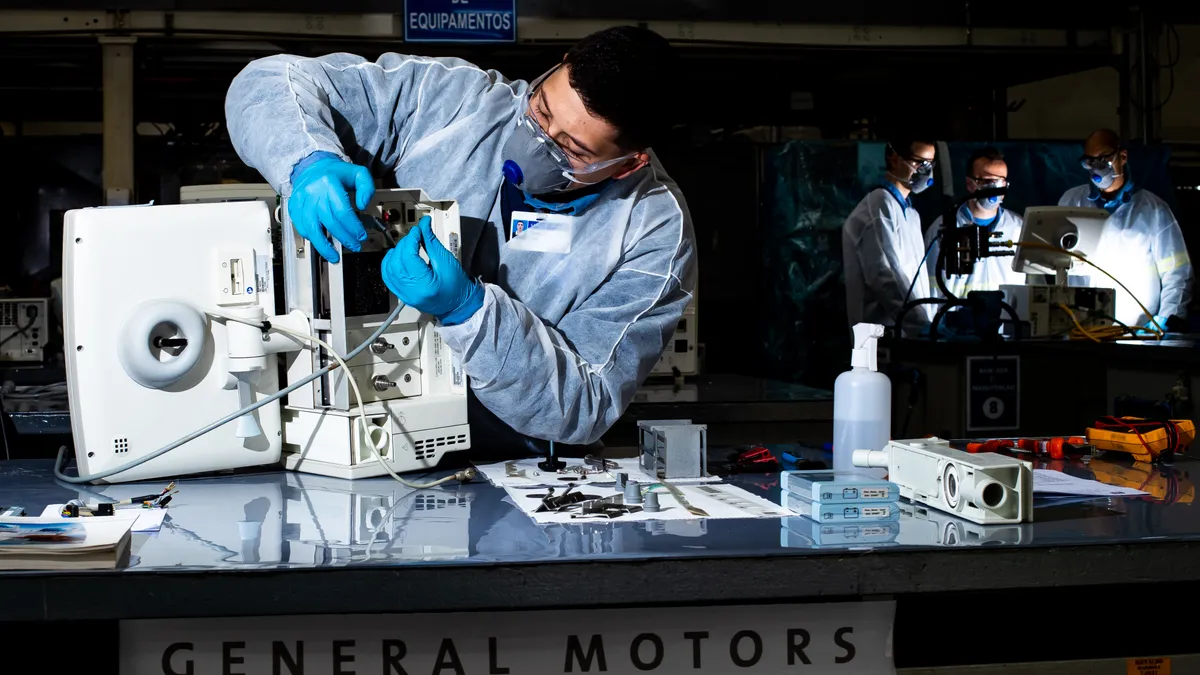 A technician is repairing a ventilator at a General Motors factory in mex