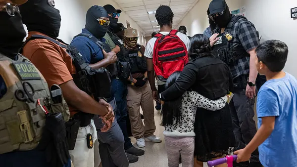 Immigration enforcement agents, including those from ICE, line the hallways outside immigration court in New York City