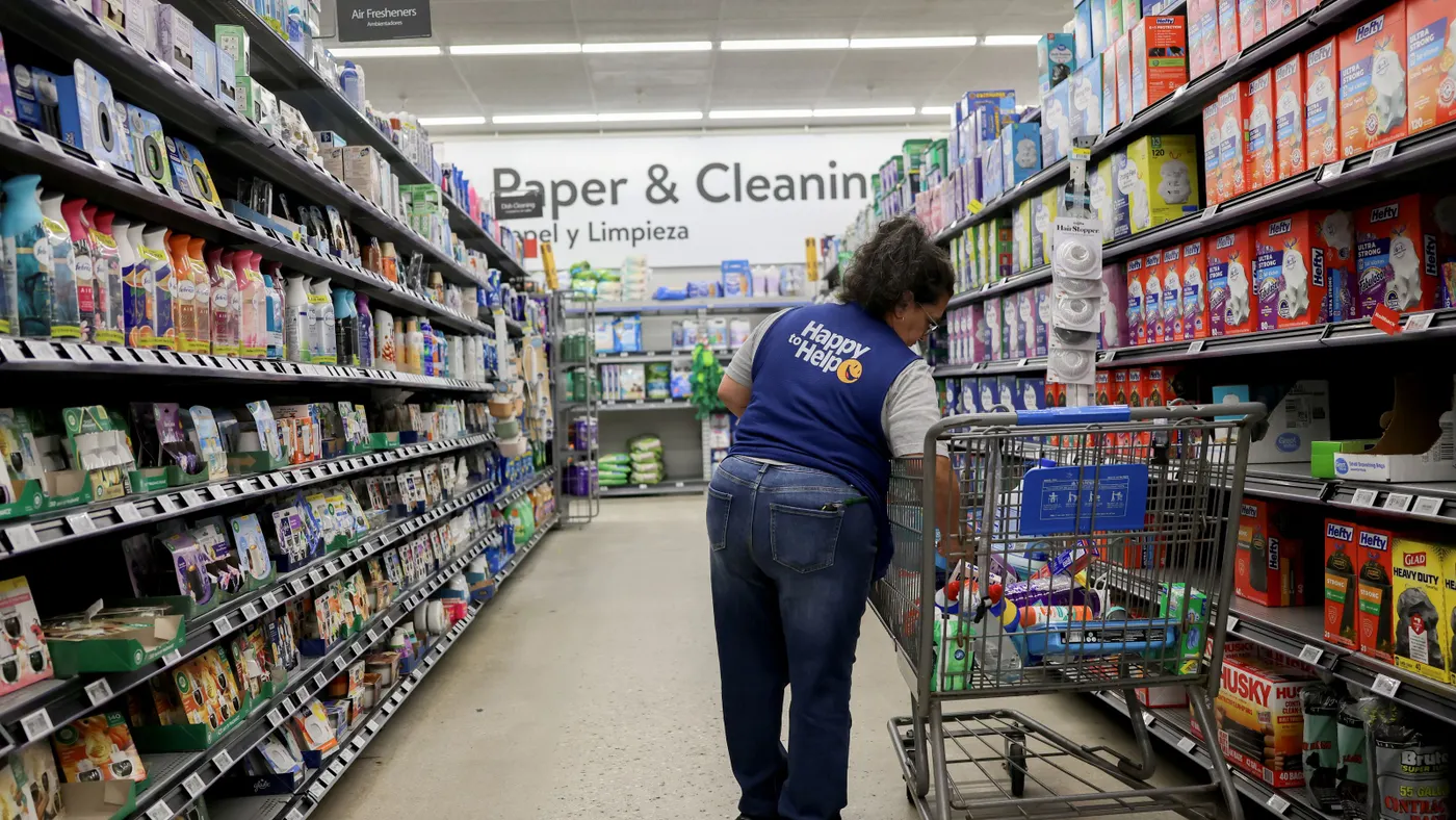 A person stocks shelves inside a Walmart retail store.