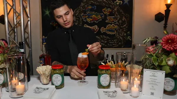 Bartender prepares Aperol Spritz signature cocktails.