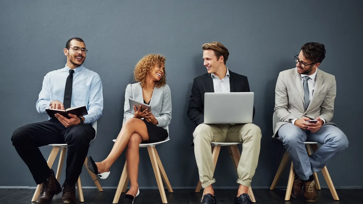 Full length shot of a group of businesspeople waiting in line for a job interview.