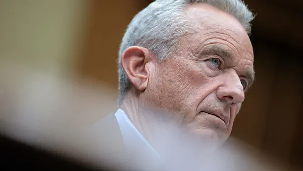A close-up of a person in a suit looking off to the right.