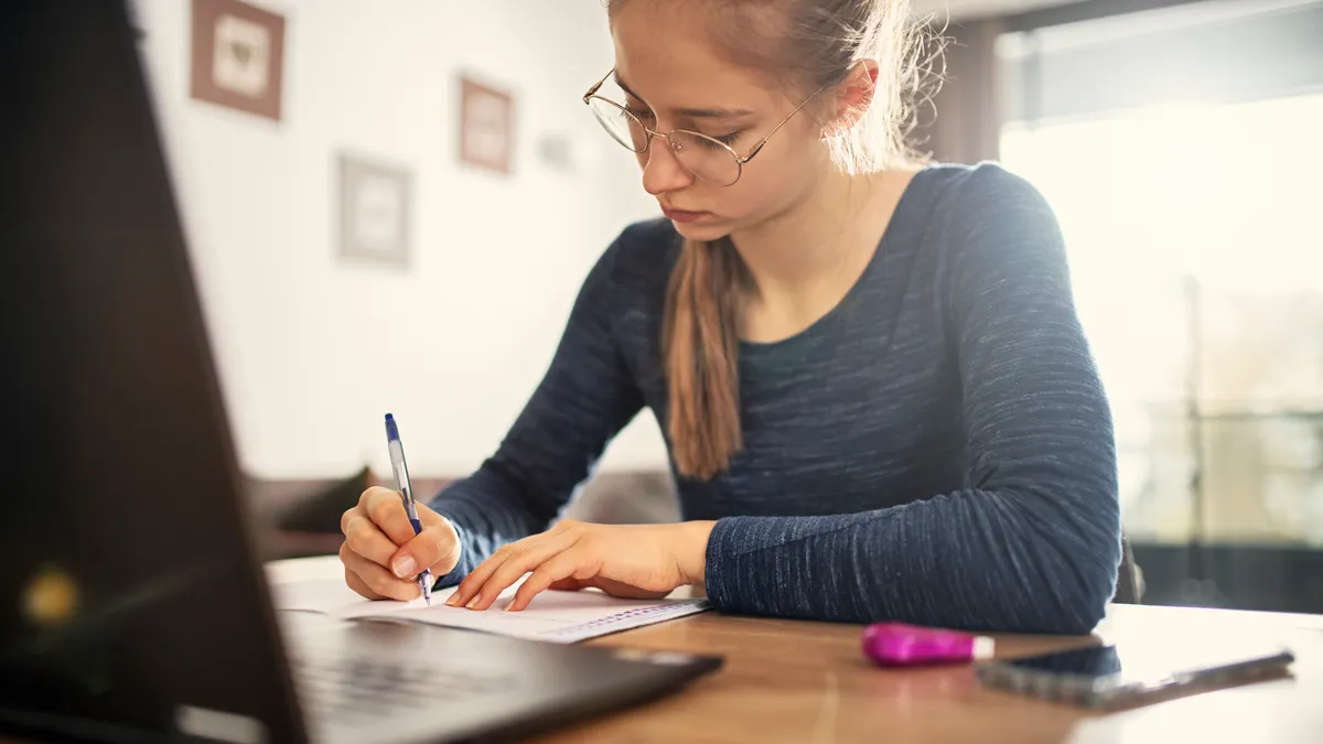 A student works on an assignment on their computer at home.