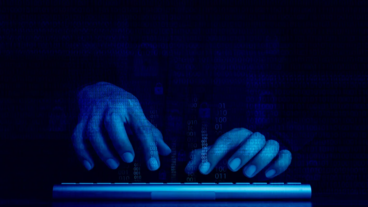 Digital code data numbers and secure lock icons on hacker's hands working with keyboard computer on dark blue tone background.