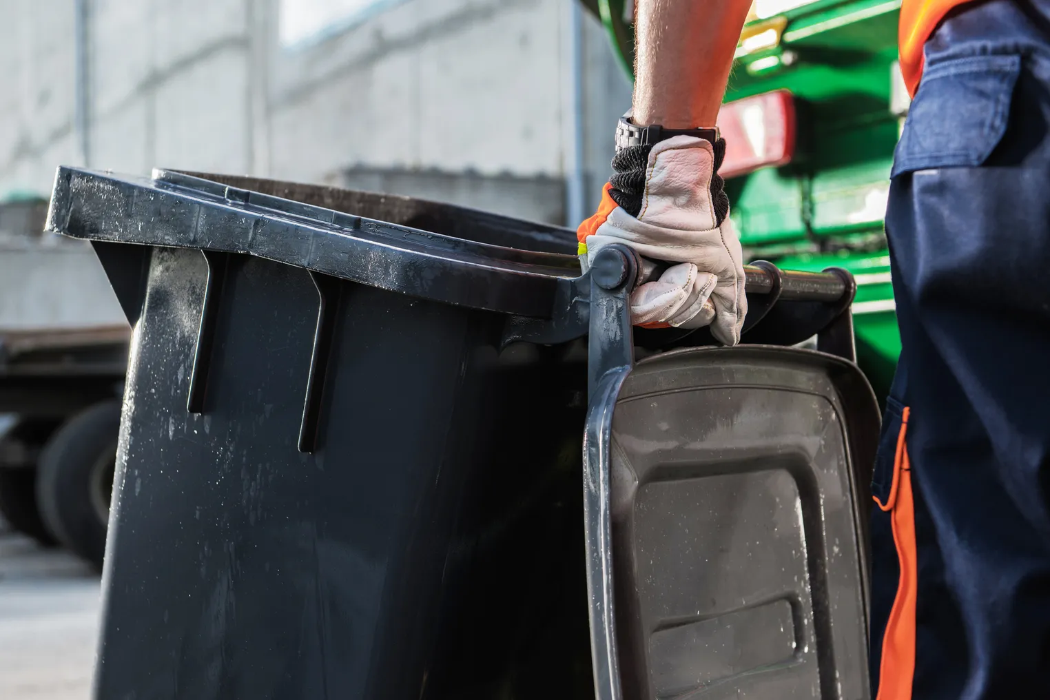 Gloved hand holding a garbage cart