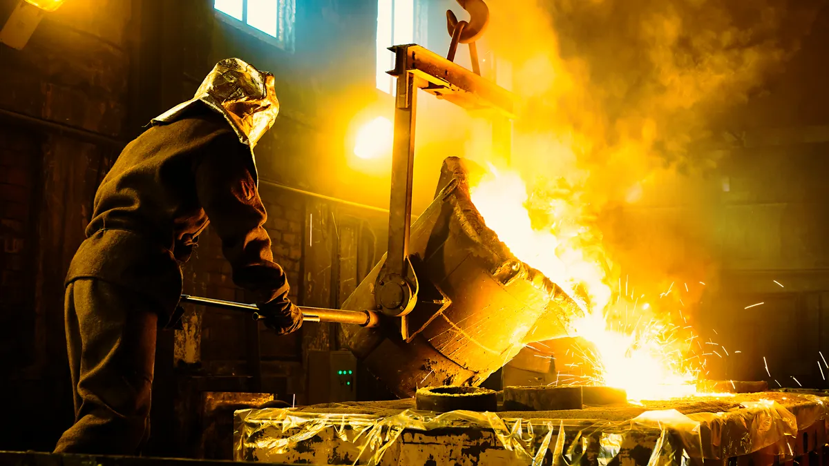 Worker controlling metal melting in furnaces.