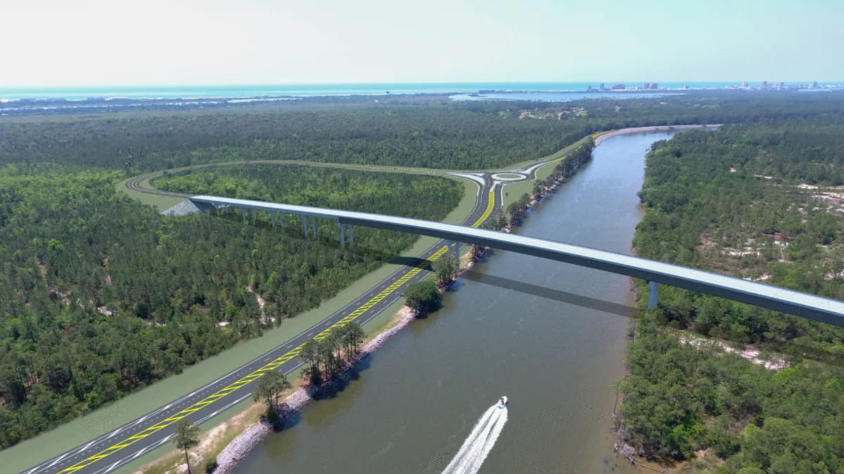 A long simple bridge spans a wide channel, with forest on either side.