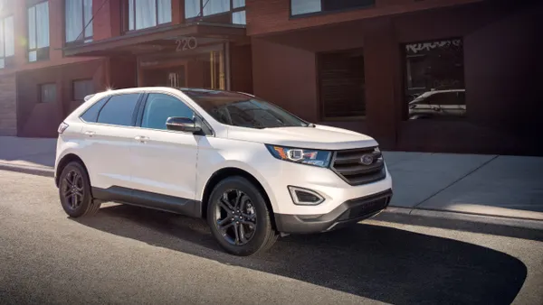 A white 2018 Ford Edge SEL with the optional Sport Appearance Package on a street in front of a building.