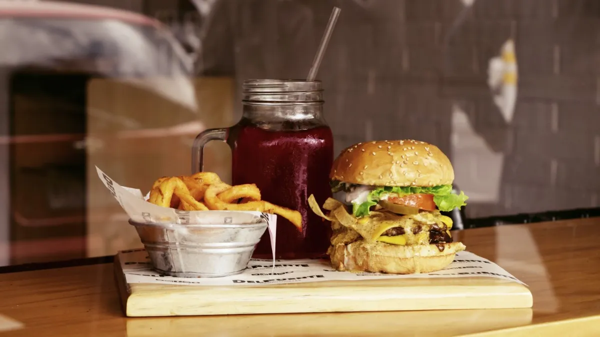 A burger and fries and juice at a restaurant