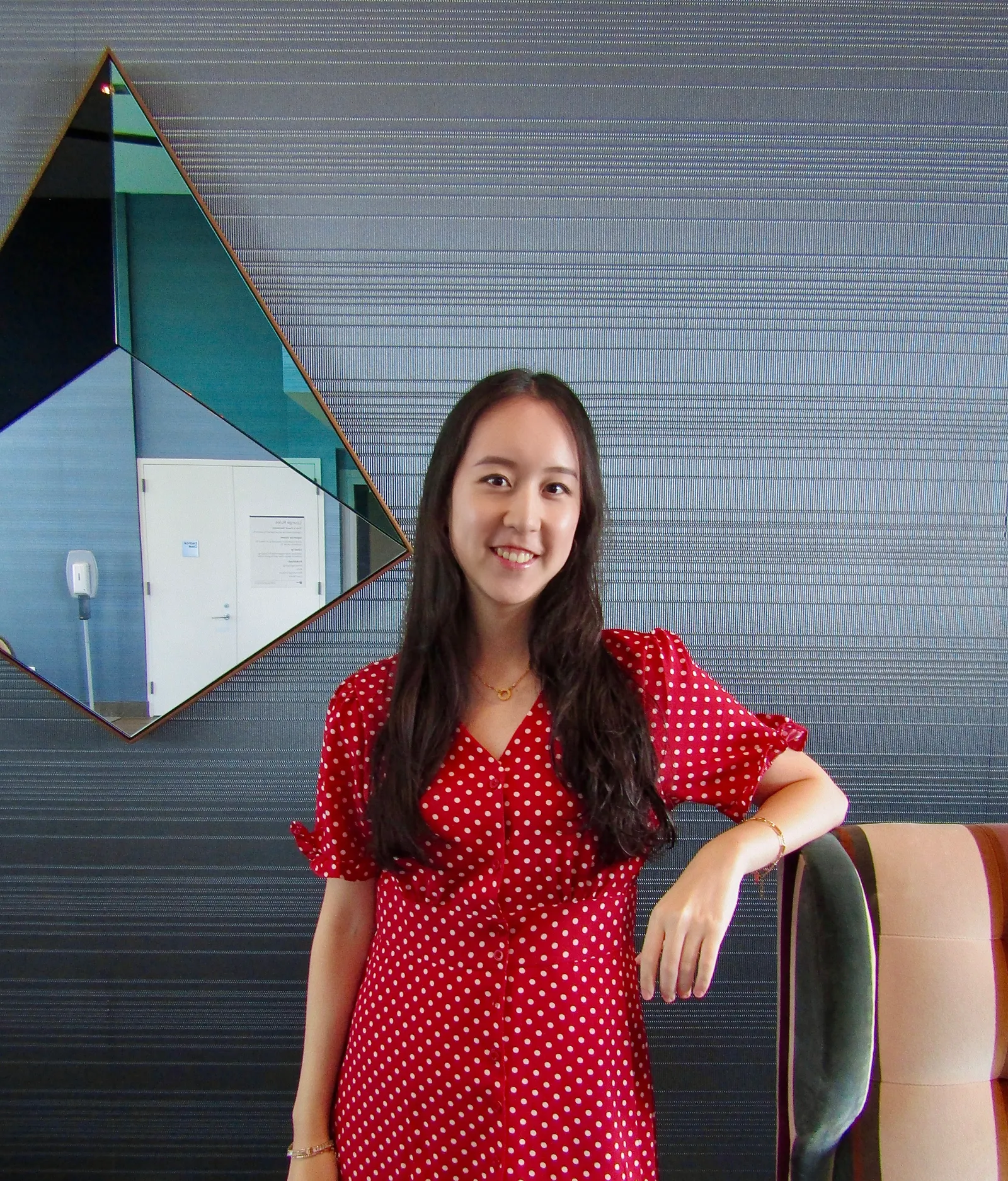 Woman standing in front of a neutral background in a red dress