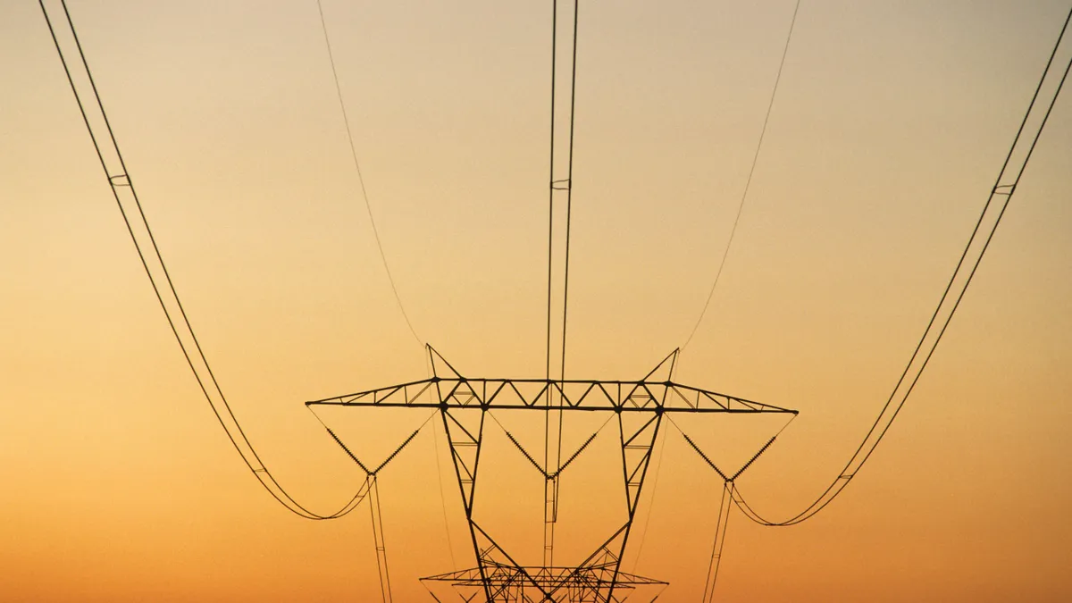 Pylon with power lines against reddish sky at sunset, rural North Carolina, USA.