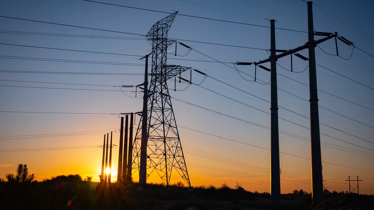 Silhouette of power line infrastructure at sunset