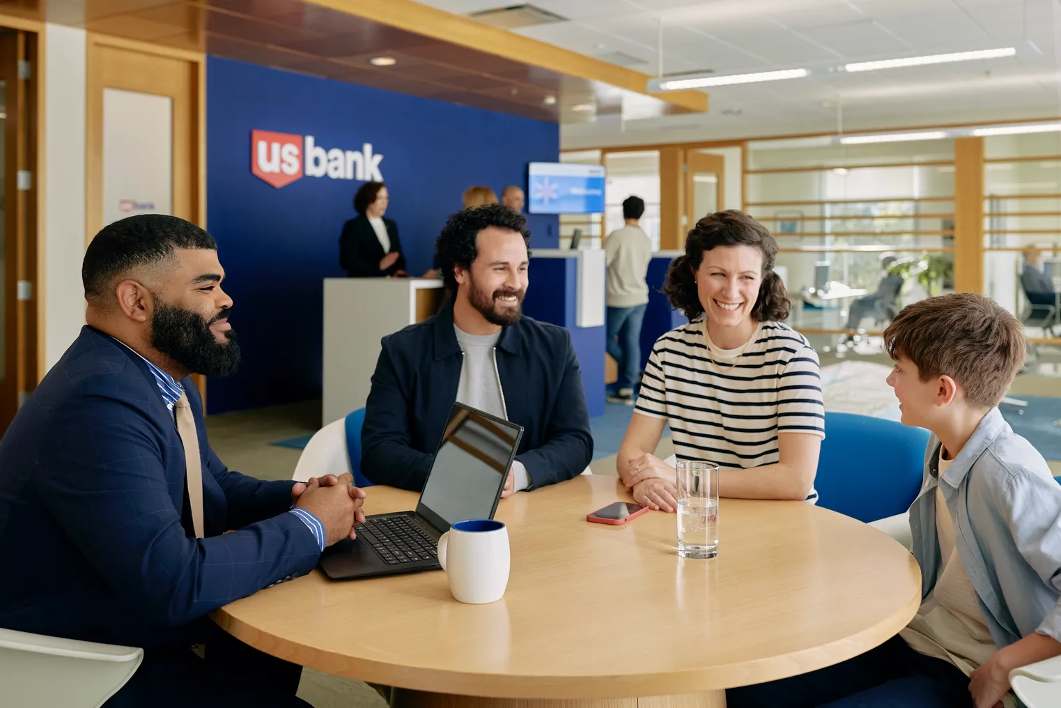 Four people sit at a table in a U.S. Bank location