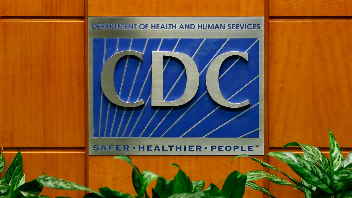 A podium showing the logo for the Centers for Disease Control and Prevention is seen.