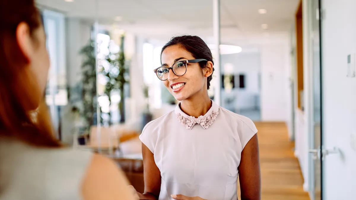 Woman in an office wearing glasses and smiling