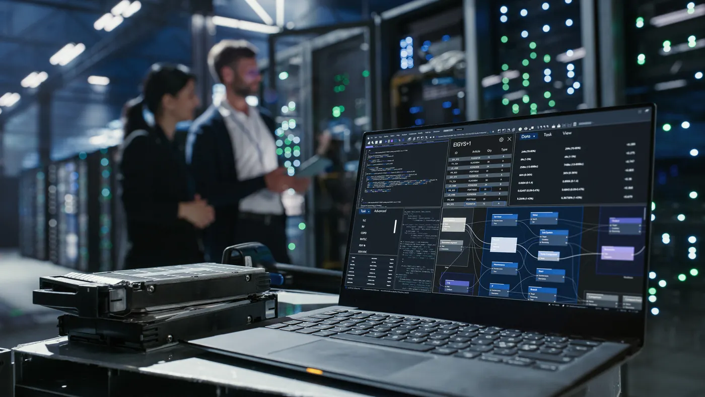 Laptop with code on screen on a table inside a server room