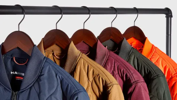 Hawke & Co. puffer jackets in various colors are hanging on a rack.