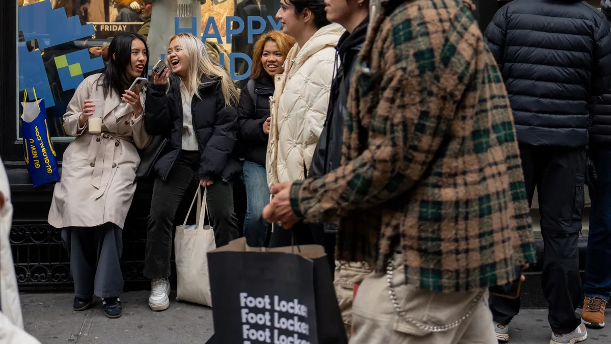 Shoppers walk by a storefront