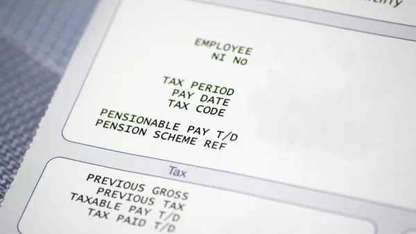 A close-up of a paper pay slip with tax and pension information.