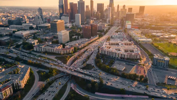 Aerial view of a big city with tal buildings surrounded by multilane highways.