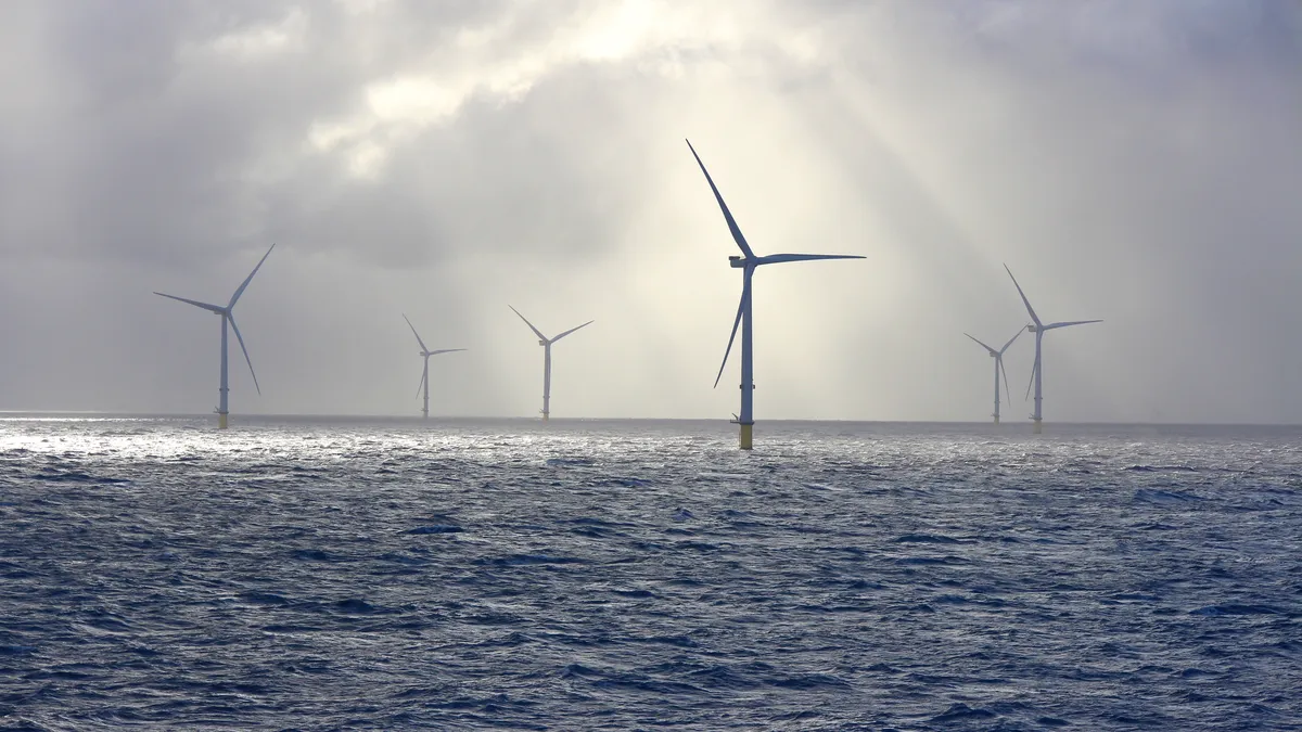 A beautifully lit scene with sunbeams on an offshore wind farm turbine.