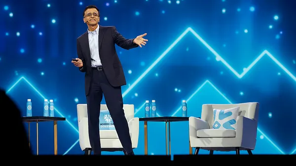 an executive speaks on stage in business attire
