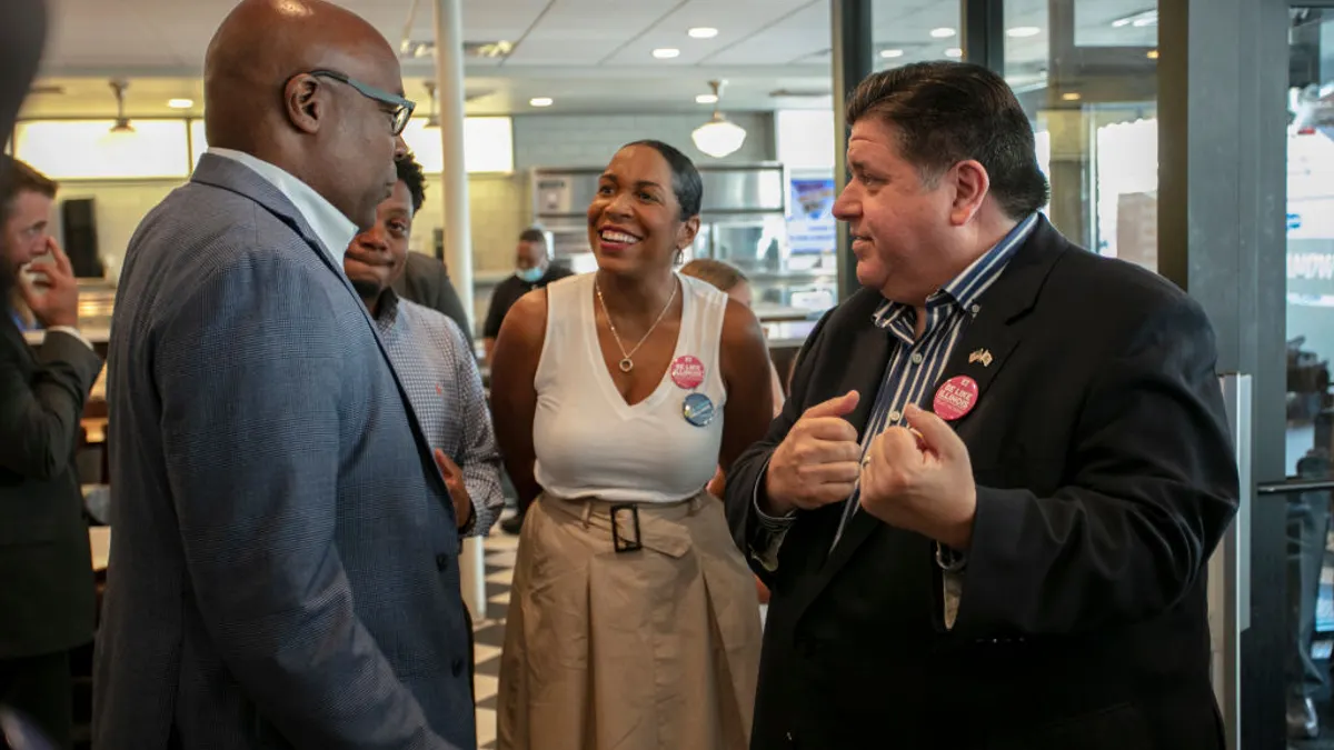 Illinois Attorney General Kwame Raoul (L) speaks to Illinois Governor J.B. Pritzker (R)