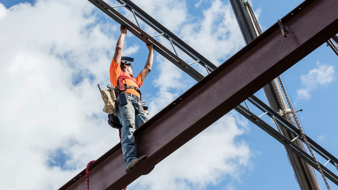 Ironworker at construction site installing roof joist stock photo