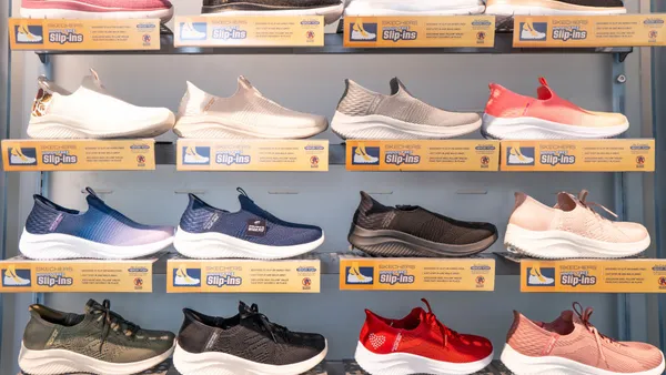 A wall display of multiple Skechers sneakers in a store.