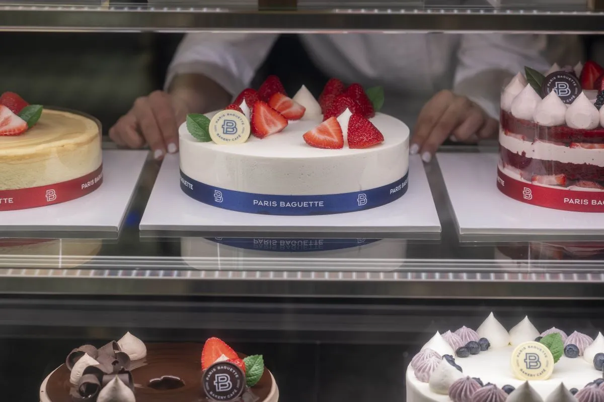 An image of various cakes behind a display case.