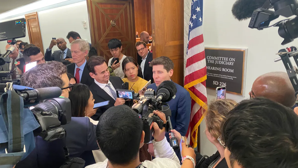 Sam Altman, CEO of OpenAI, standing outside of a Congress hearing room