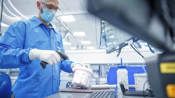 Senior Research Associate Tanya Quint loads one of the instruments used to run Exact Sciences' Cologuard test at the company's headquarters in Madison, Wis. (Photo: Business Wire)