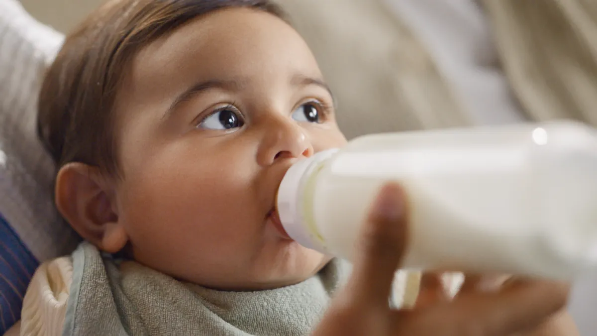 baby being fed formula in a bottle