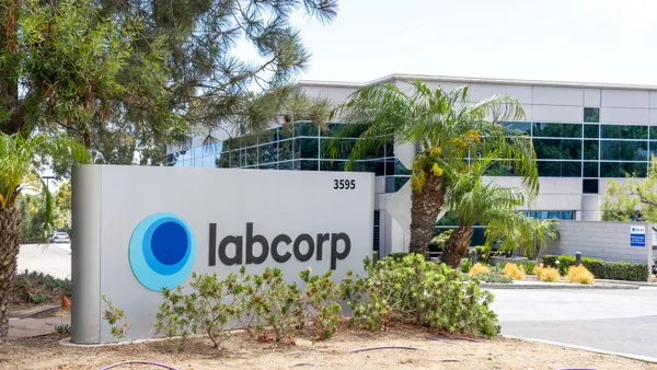 A Labcorp sign in front of an office building and palm trees.
