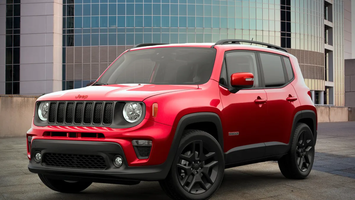 A 2022 red Jeep Renegade SUV with a building in background.