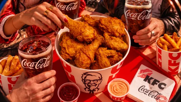 A bucket of fried chicken from KFC surrounded by Coca-Cola glasses