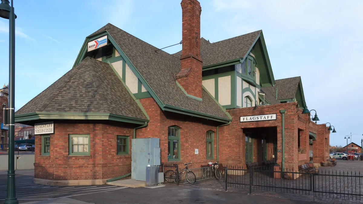 A red brick building with an Amtrak sign alongside a railroad track.