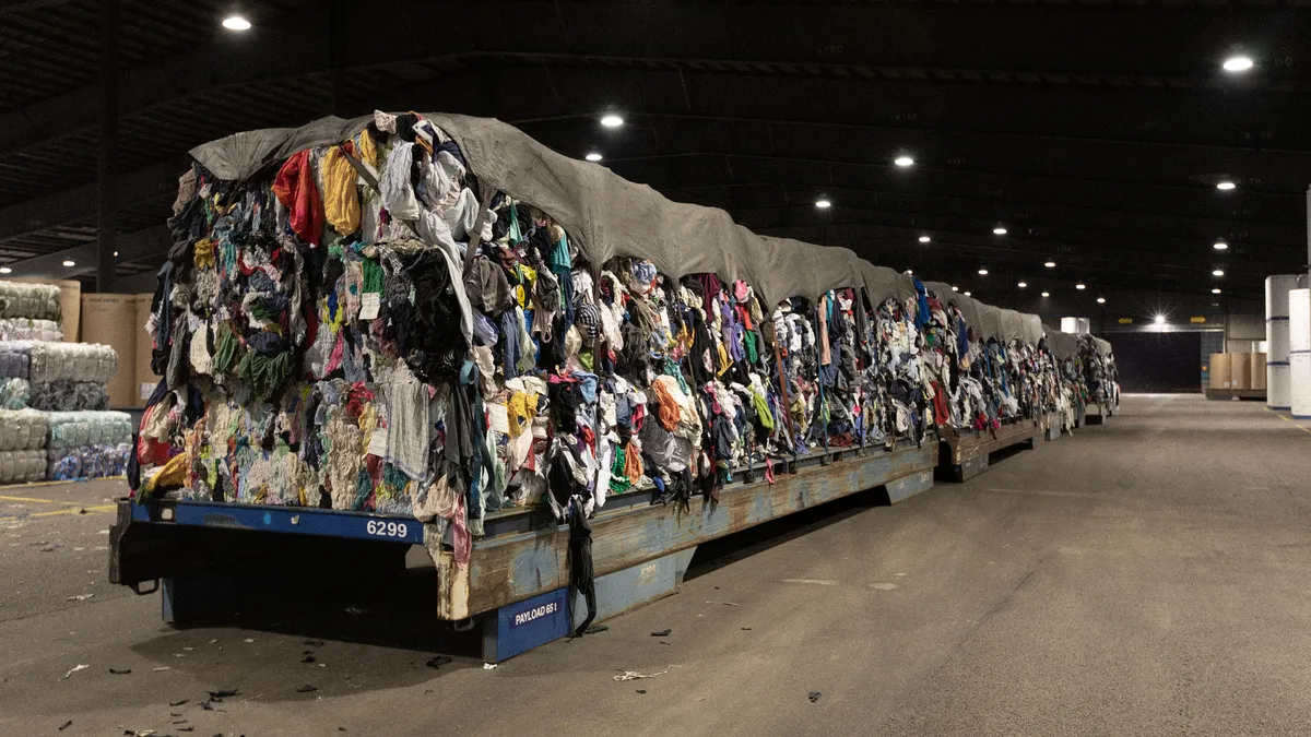 A vast pile of clothes is pictured in a warehouse.