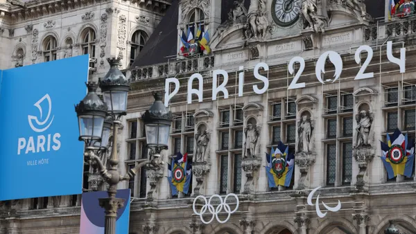 Paris 2024 olympic signage hangs on a building.