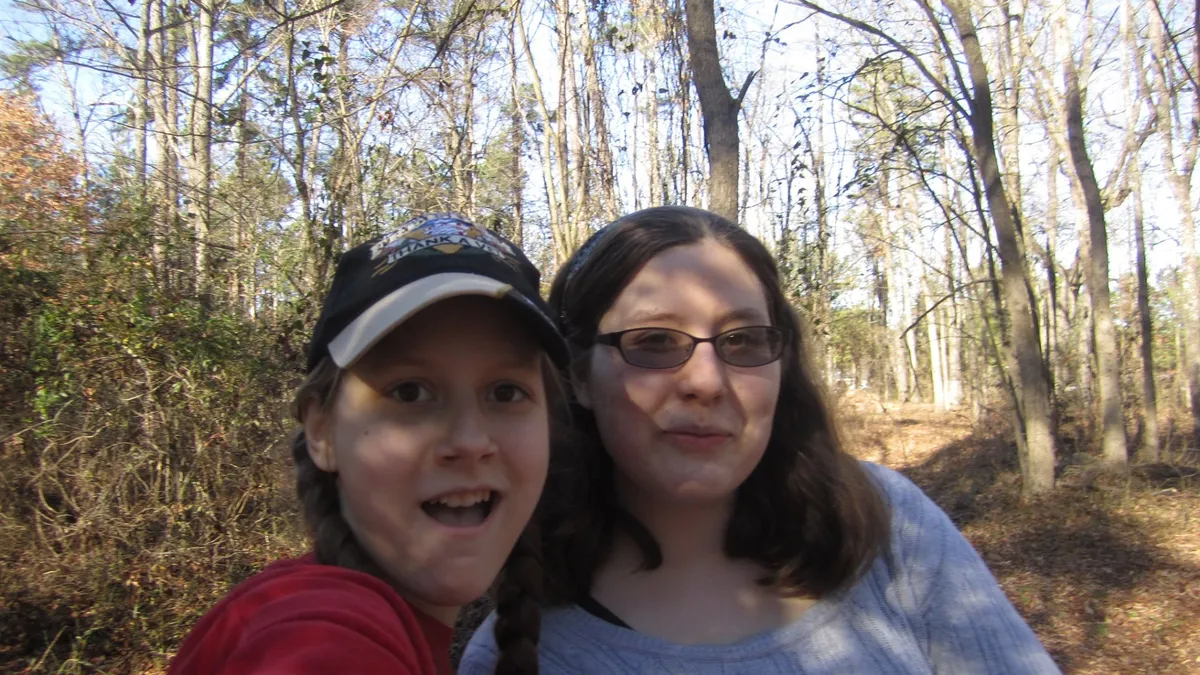 Mary (left) and AnnaLeah (right) capturing themselves on camera outside.