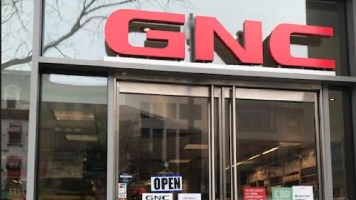 GNC storefront with yes we are open sign.