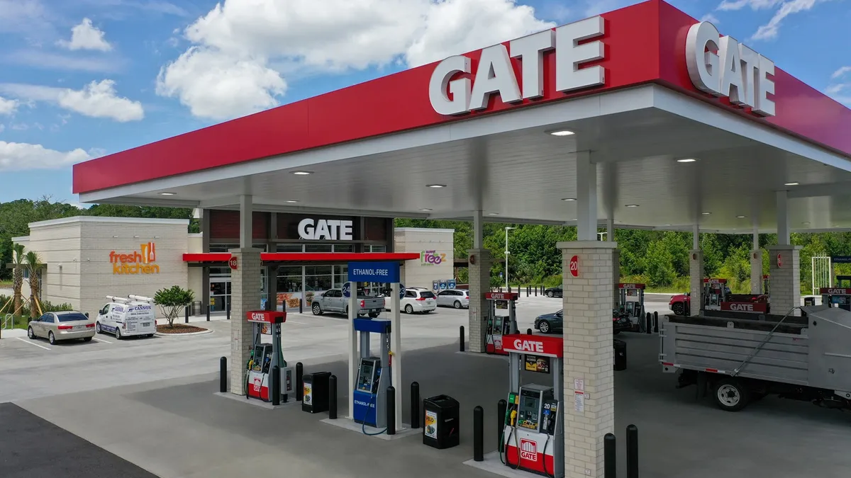 A photo of the exterior of a gas station and convenience store. Signs on the canopy and store says "Gate" and a second sign on the store says "Fresh Kitchen."