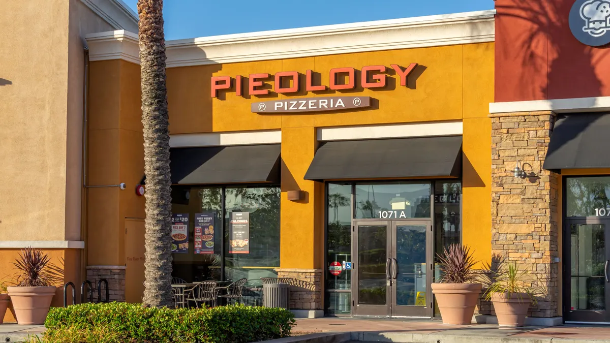 An image of a storefront with a sign that says Pieology Pizzeria.