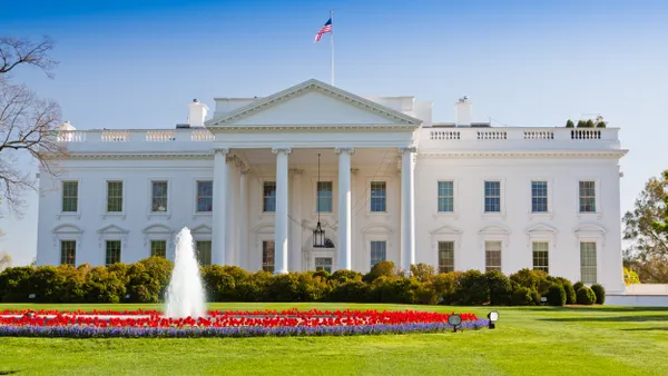 View of the White House with flowers and fountain in front.